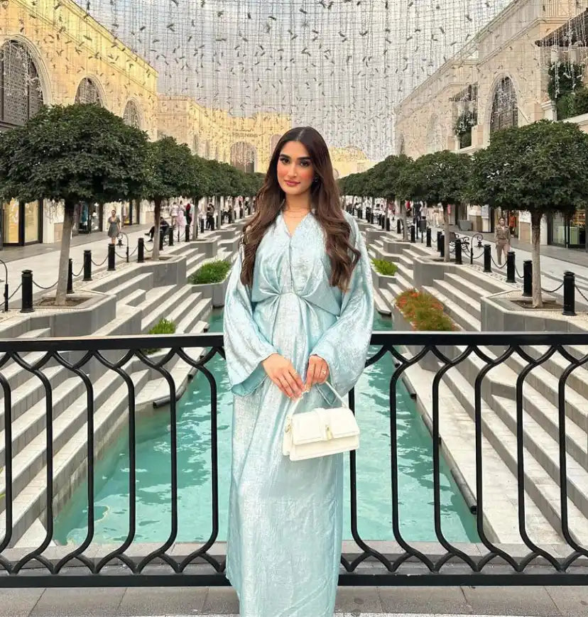Elegant light blue dress with a white handbag.